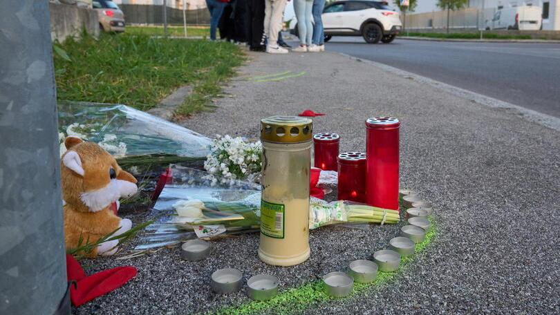 Fiori e lumini sul luogo dell’incidente mortale. Sullo sfondo gli amici di Tommaso Comelei