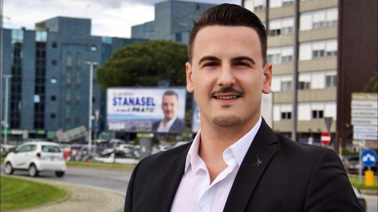 
	Claudiu Stanasel sullo sfondo del suo manifesto: "Son di Prato"

