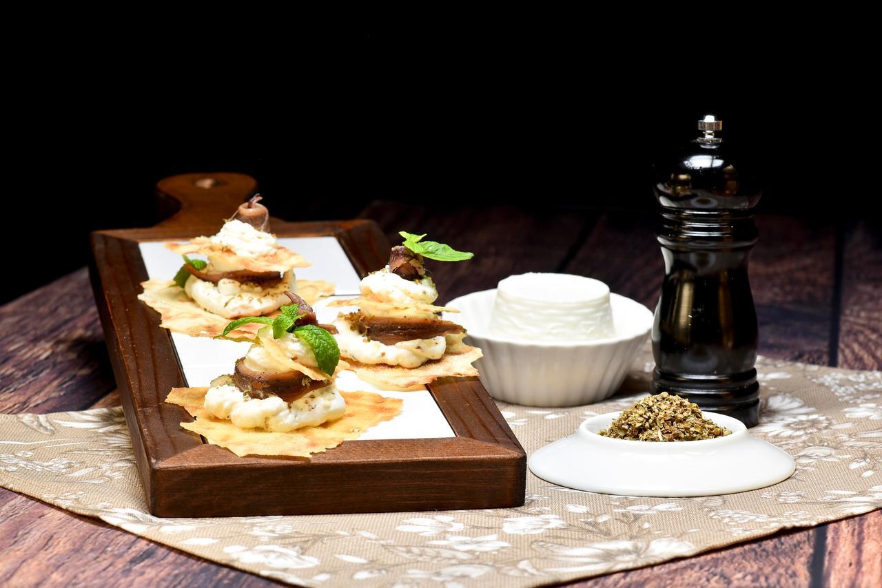 Il pane carasau condito crema di formaggio, acciughe e spezie