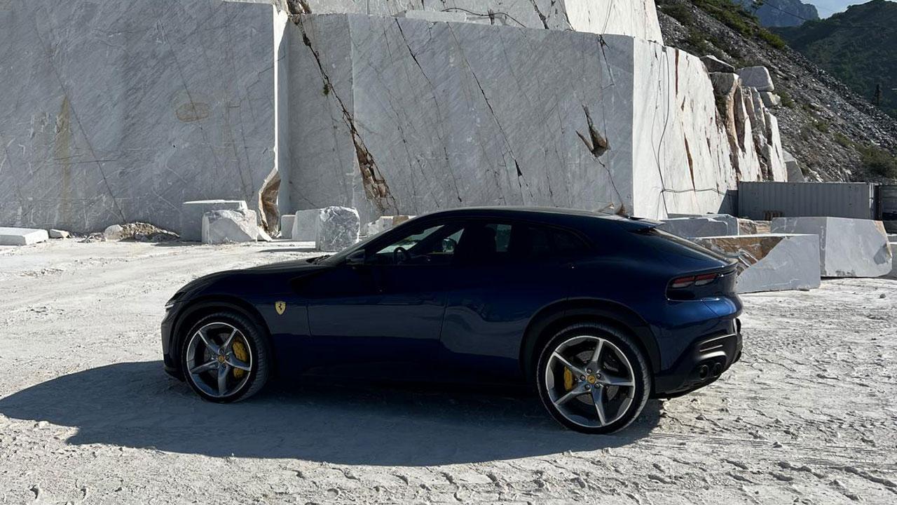 Carrara, in cava posa una Ferrari Purosangue: il motivo del set e quanto costa averla
