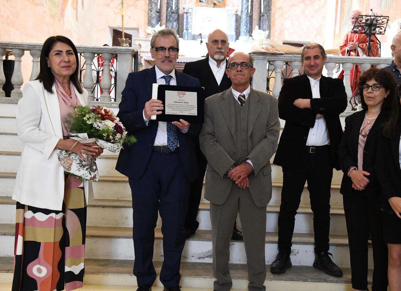 
	Un momento della premiazione. Al centro, il dottor Salvatore Salis (con la targa in mano) e, al suo fianco,&nbsp;il priore Salvatore Nieddu (foto di Massimo Locci)

