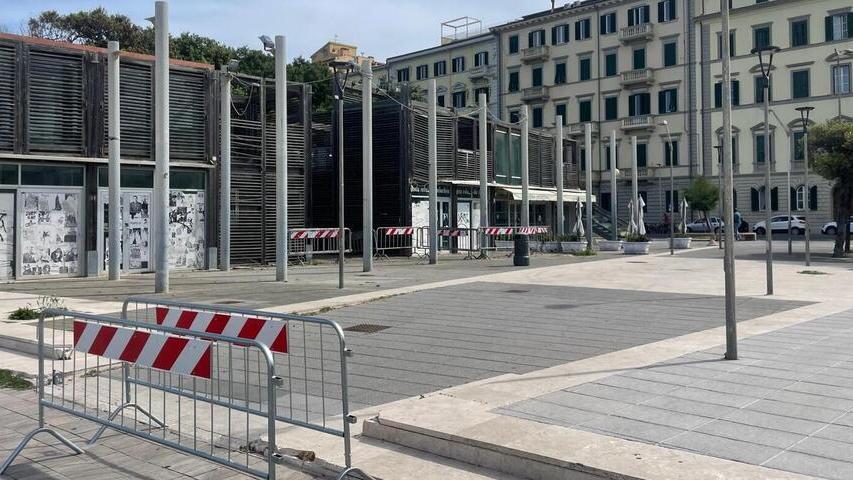 Transenne in piazza davanti alla struttura da cui crollò una scala nell’agosto scorso. In fondo la gelateria La Grotta Blu