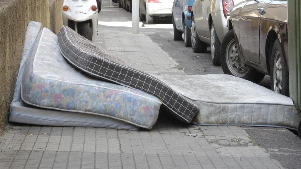 Materassi su un marciapiede in attesa del ritiro
