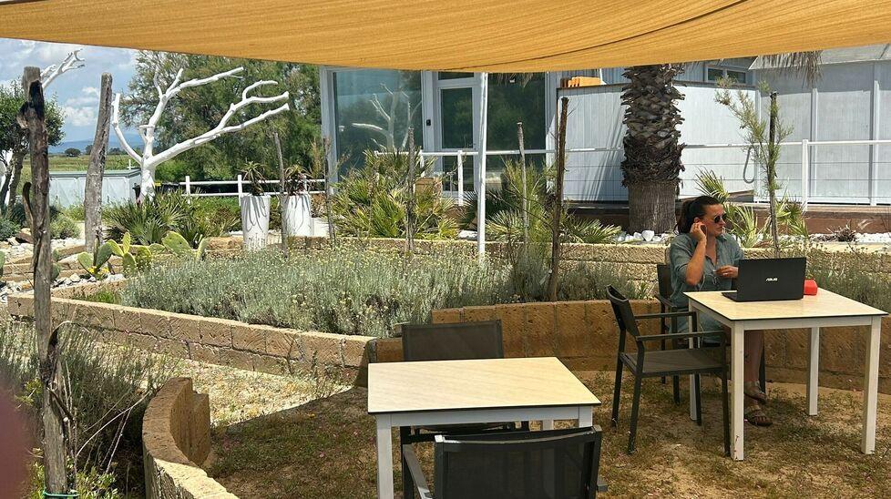 Una donna lavora al pc nello stabilimento balneare “La Capannina” a Piombino