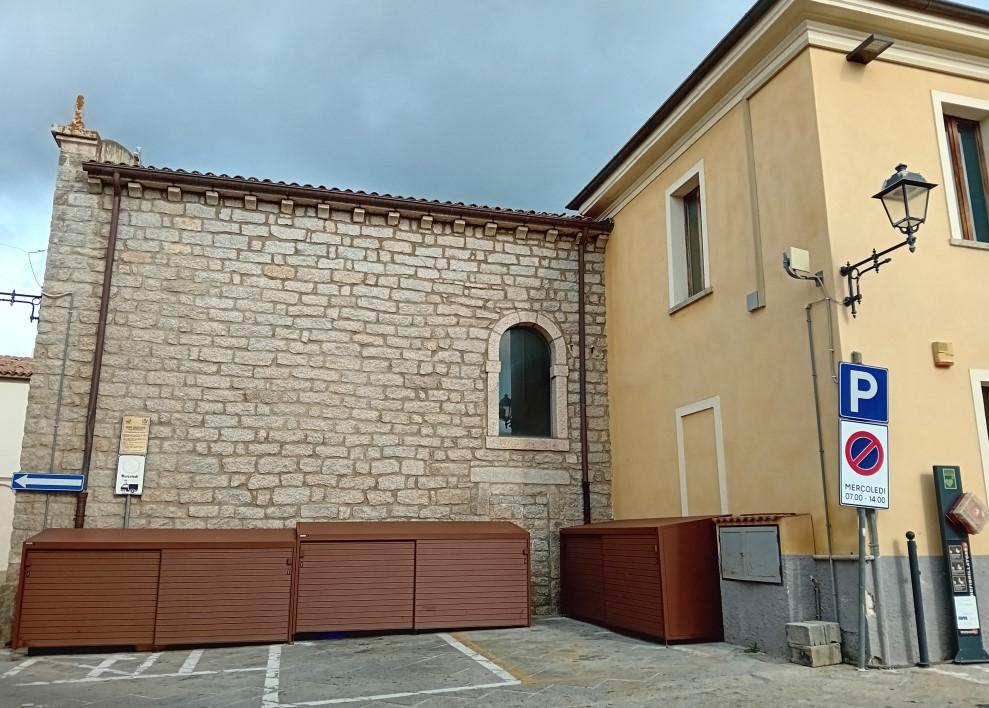Arzachena, cassonetti addossati alla chiesa. Fedeli in rivolta: «Indecoroso»