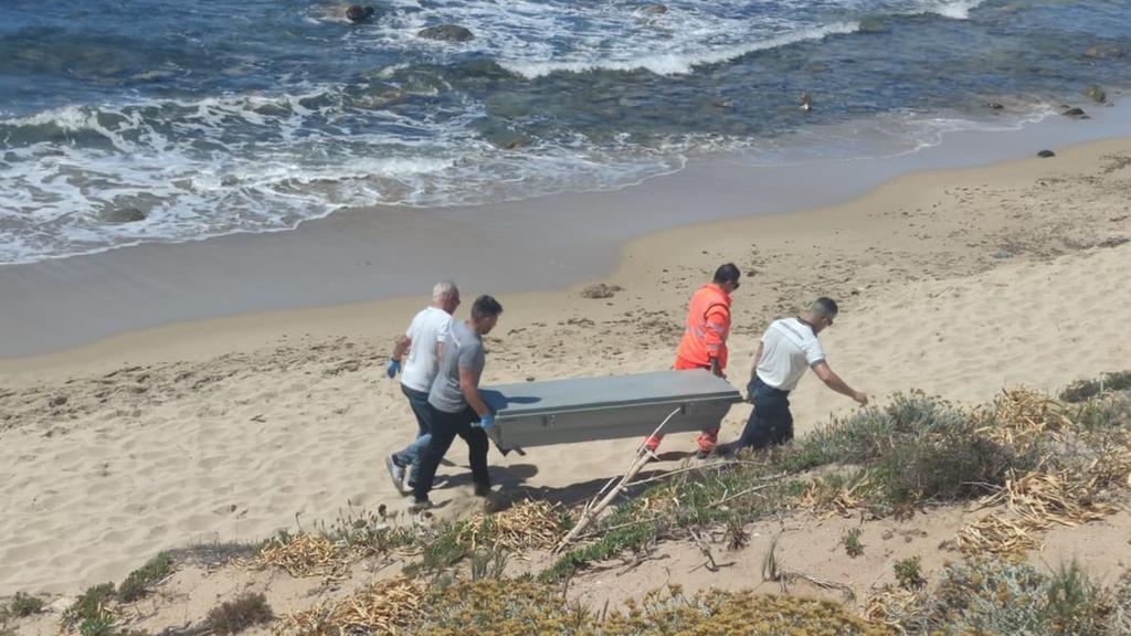 Il corpo del turista viene portato via dalla spiaggia<em> (foto Mauro Tedde)</em>