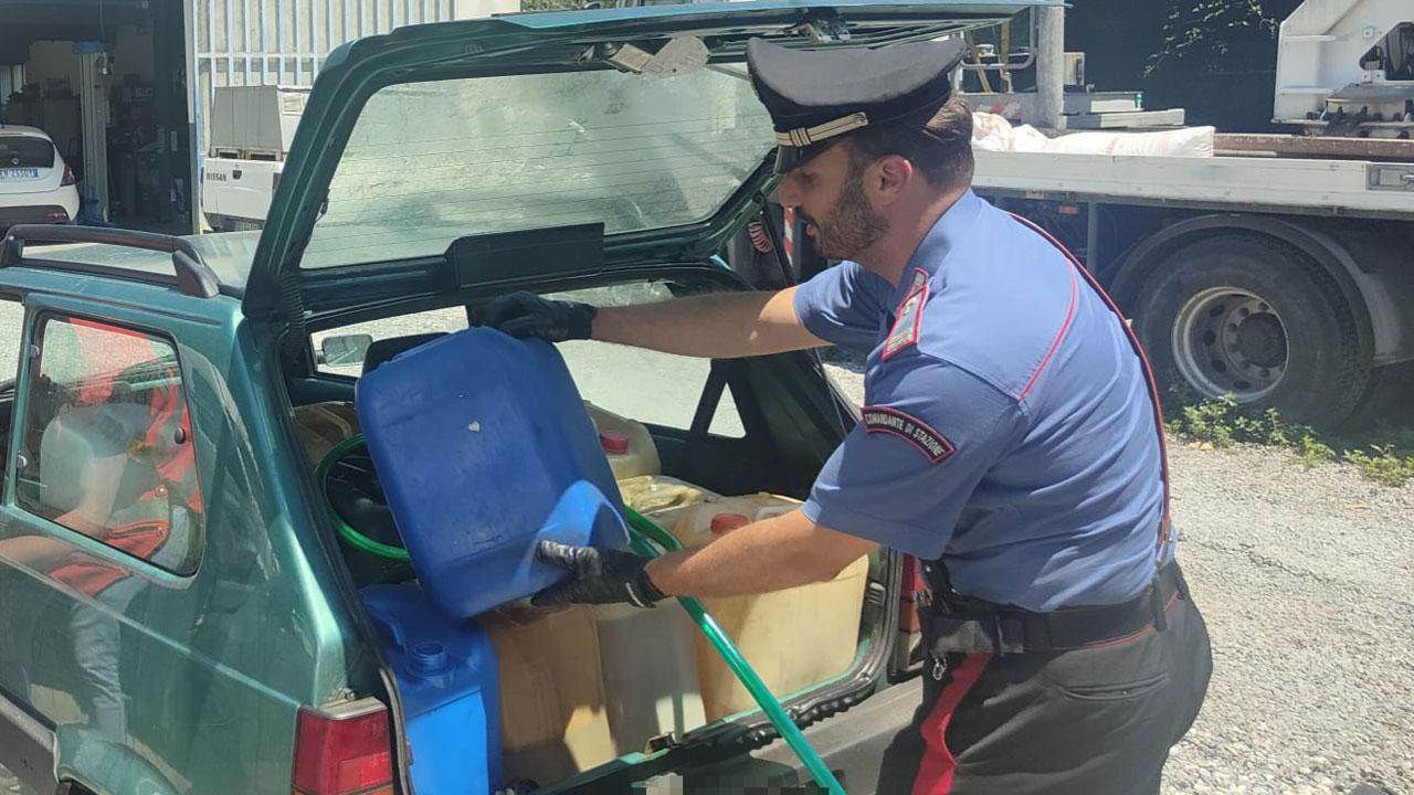 Un militare mostra la Panda rubata con le taniche per raccogliere il carburante asportato dal tir
