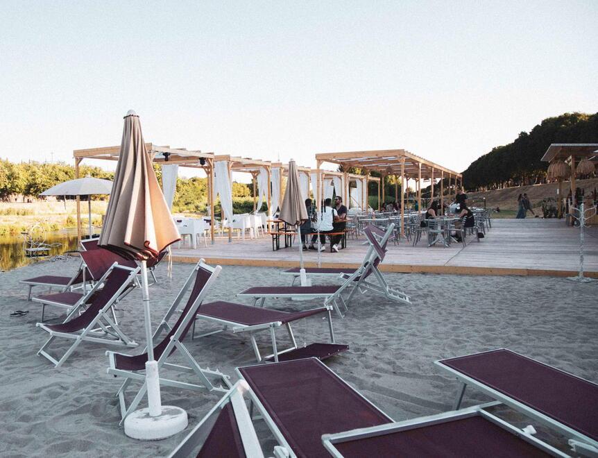 La spiaggia e le sdraio ed ombrelloni su una sponda del Bisenzio per il locale Lato B