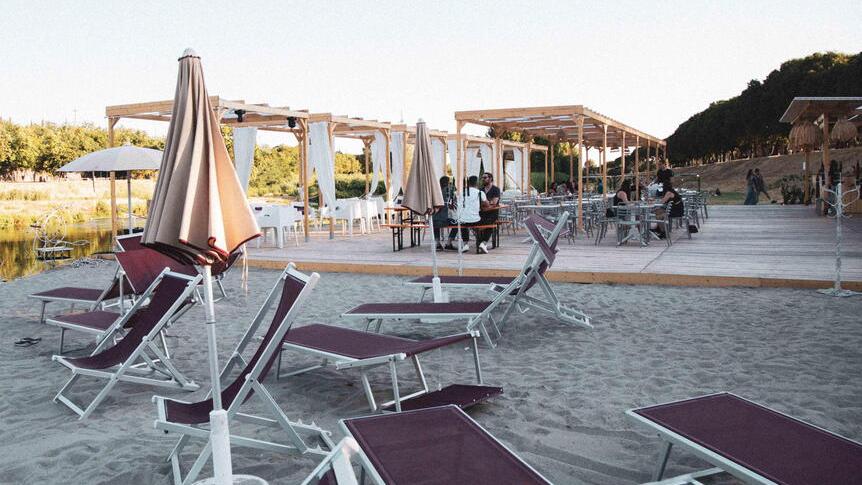 La spiaggia e le sdraio ed ombrelloni su una sponda del Bisenzio per il locale Lato B