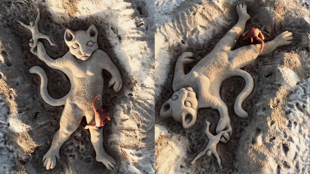 Un gatto che lancia un uomo, la nuova scultura sulla sabbia dell’artista Nicola Urru dopo i fatti di Lanusei