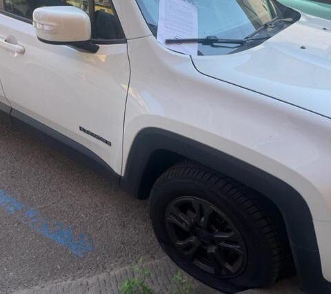 Una delle auto prese di mira in piazza San Silvestro a Pisa con il volantino di rivendicazione