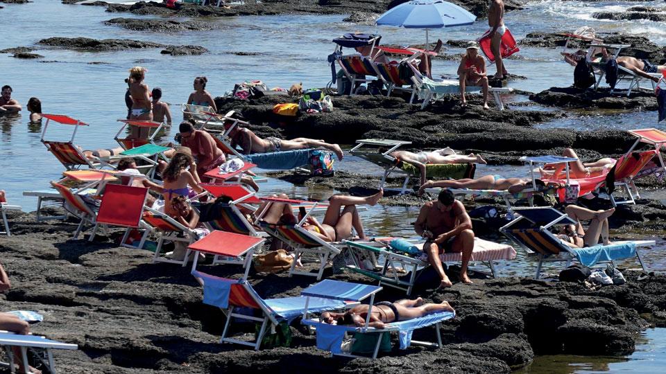 
	Uno scorcio del litorale tra lettini e chi si rinfresca in mare

