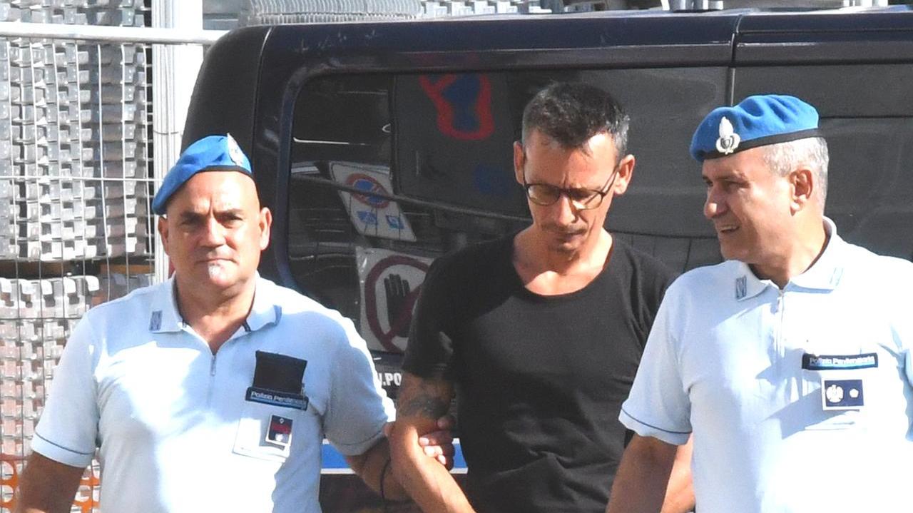 Andrea Giuntoli affiancato dagli agenti di polizia penitenziaria all'ingresso in tribunale