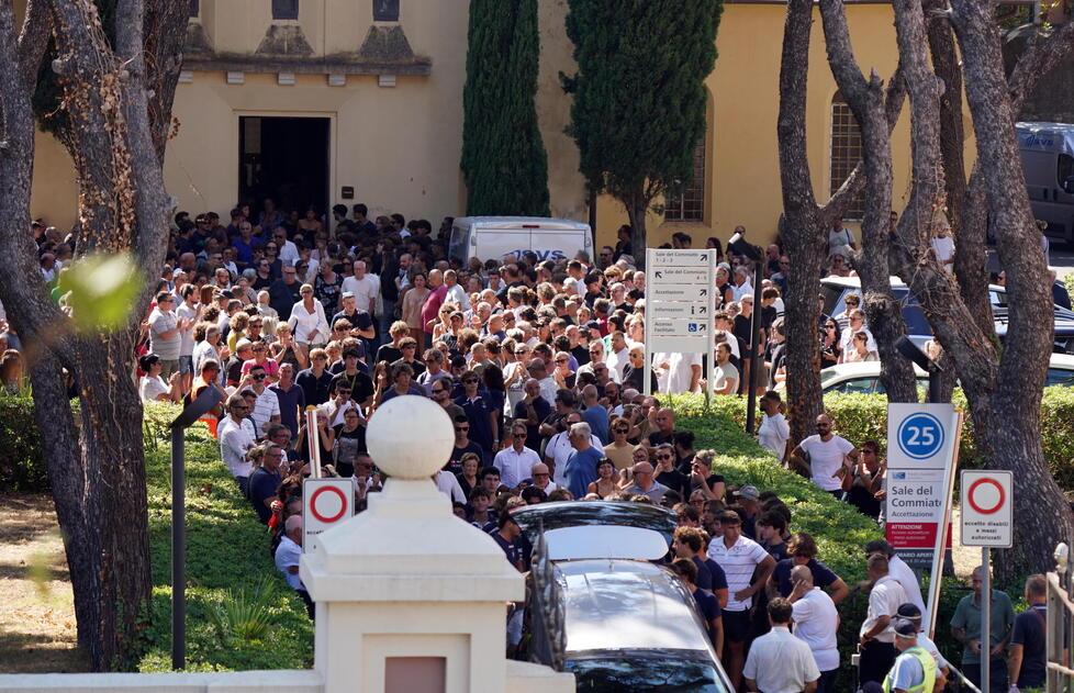 
	La folla che segue il feretro fuori dalla chiesa

