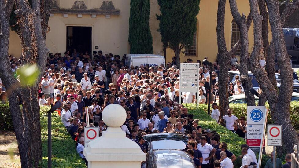 La folla che segue il feretro fuori dalla chiesa