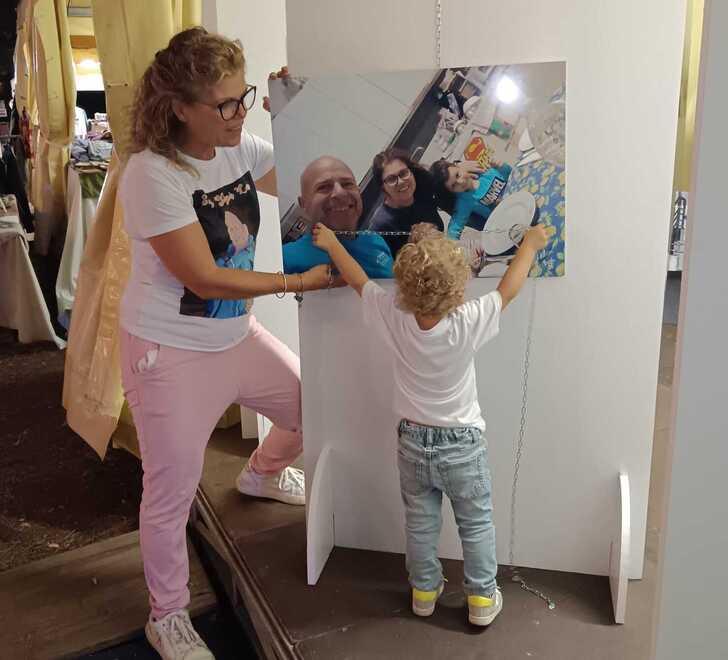 
	La piccola Viola con mamma Lucia davanti alla foto della famiglia Giannecchini

