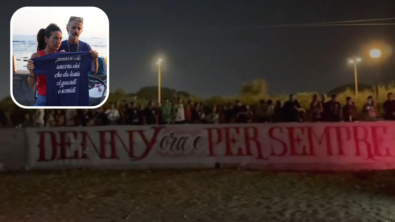 Lo striscione per Denny davanti alla Vela e i genitori che mostrano la maglietta: "Denny Vive" 