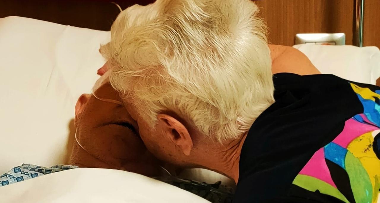 
	Il bacio tra i due anziani coniugi all'Hospice Fiore di primavera

