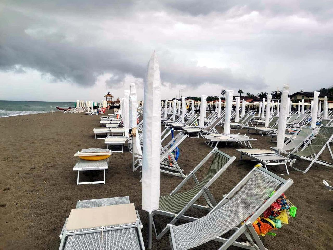 
	Ombrelloni chiusi sulla costa apuana (foto Cuffaro)

