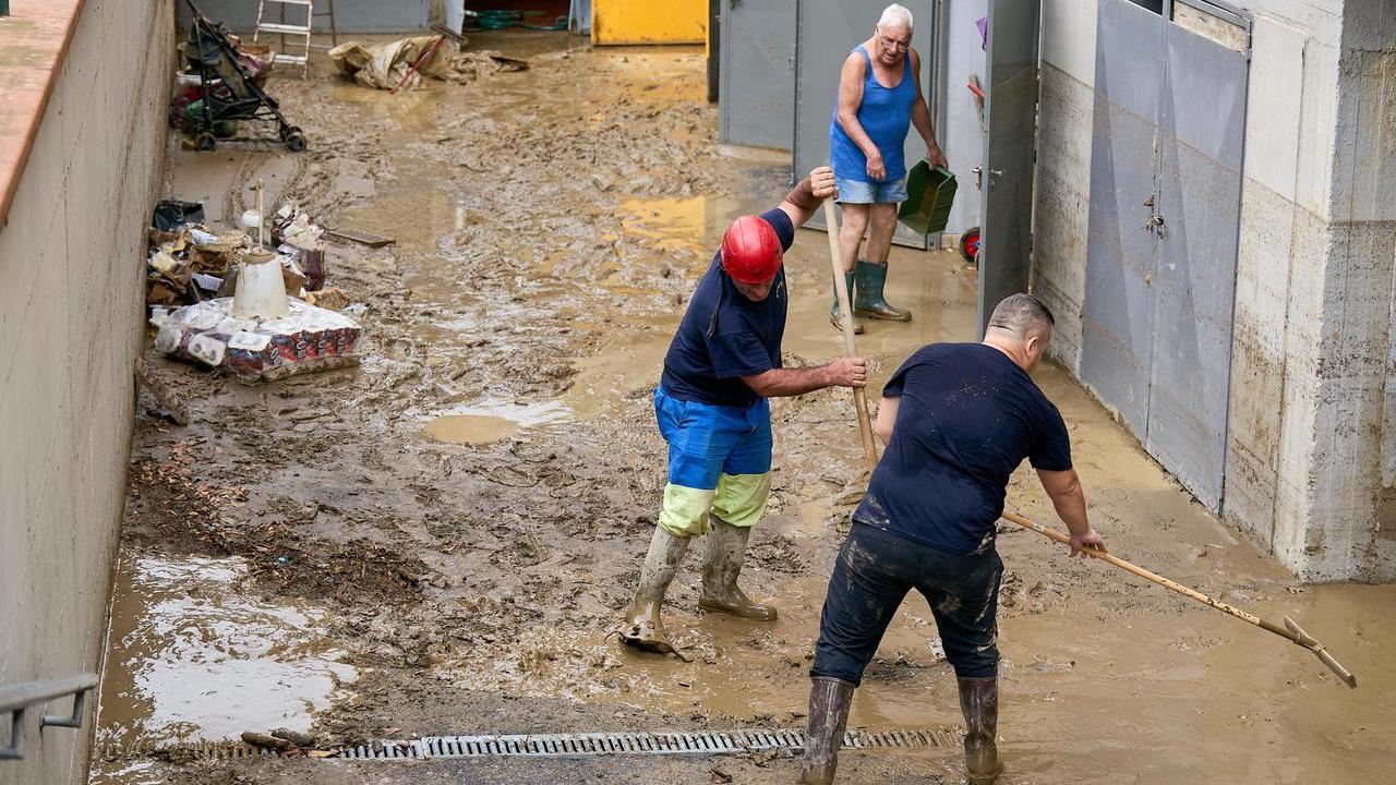 In via Fratelli Cervi si spala il fango dopo l'esondazione dello Stregale (foto Autovino)