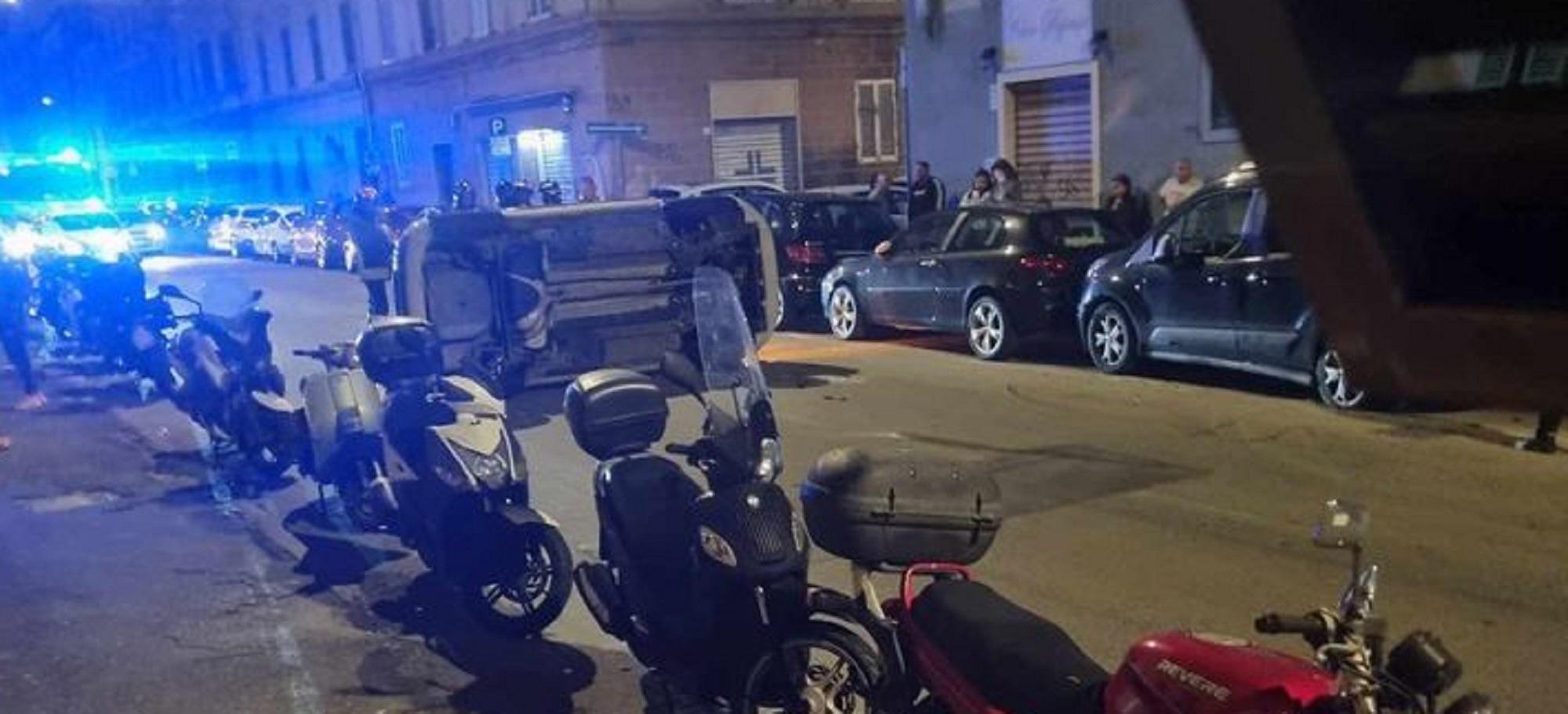 I vigili del fuoco mentre rimuovono l'auto ribaltata