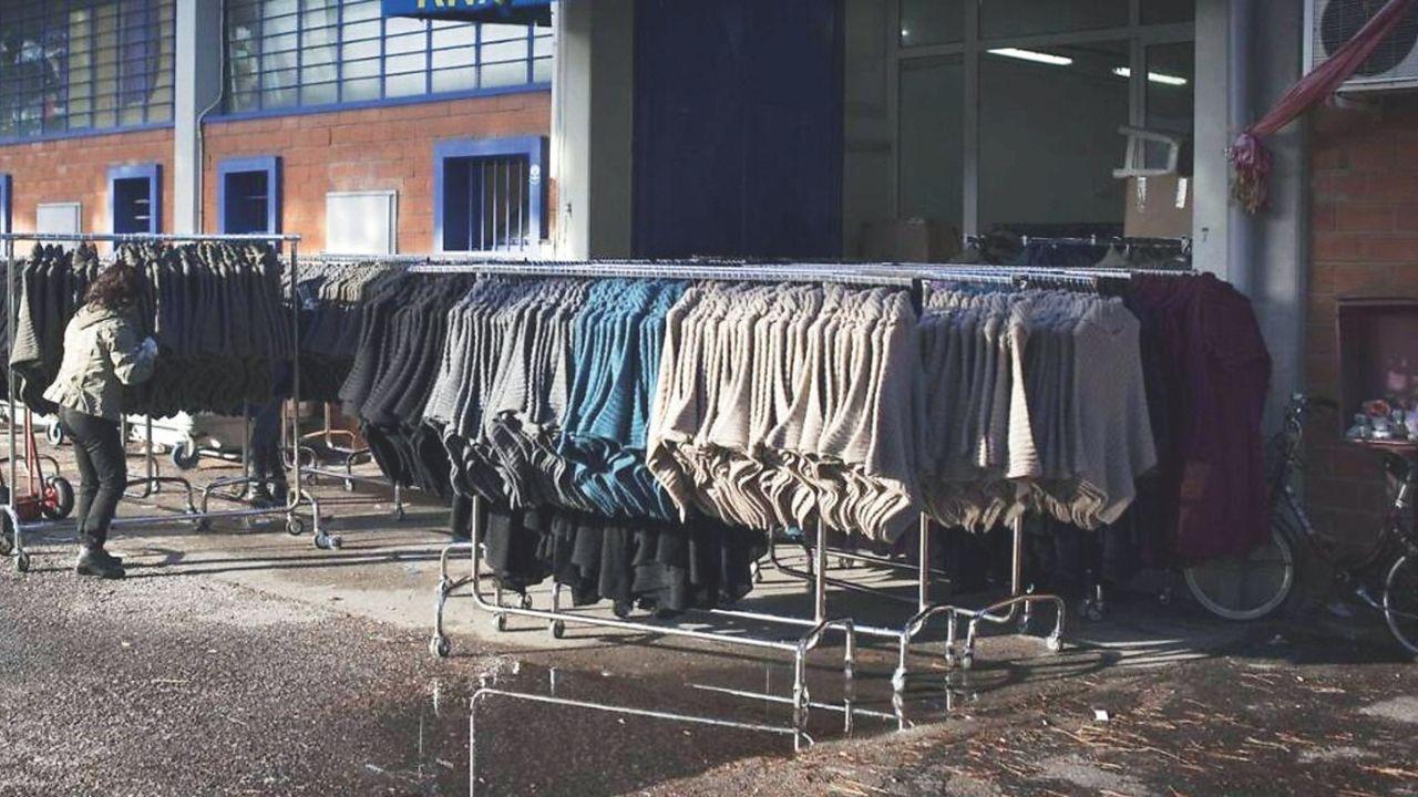 In alto indumenti esposti all’esterno di un pronto moda cinese del Macrolotto di Iolo