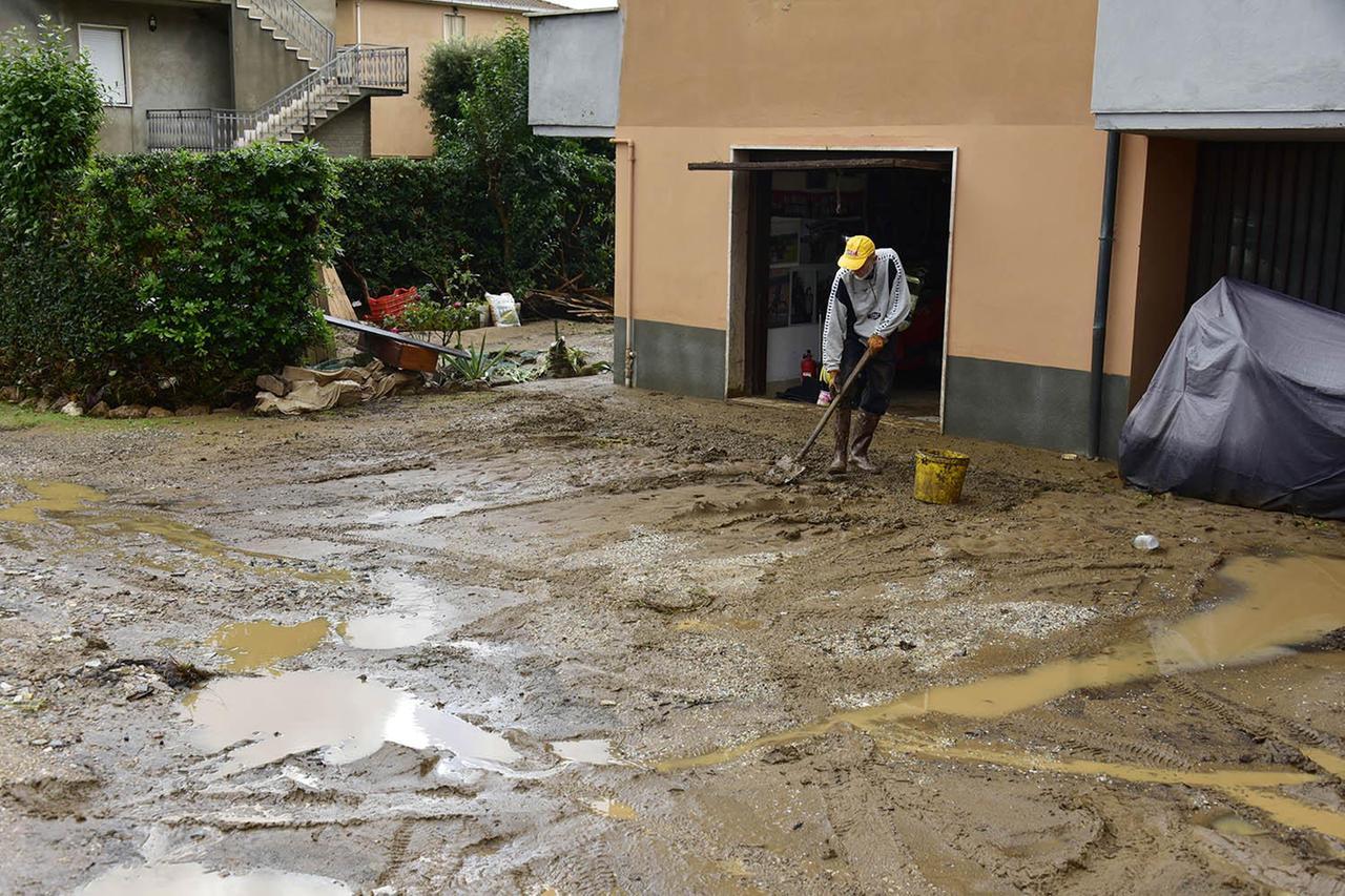 
	Un uomo che spala il fango dopo l'alluvione a Venturina (Foto Paolo Barlettani)

