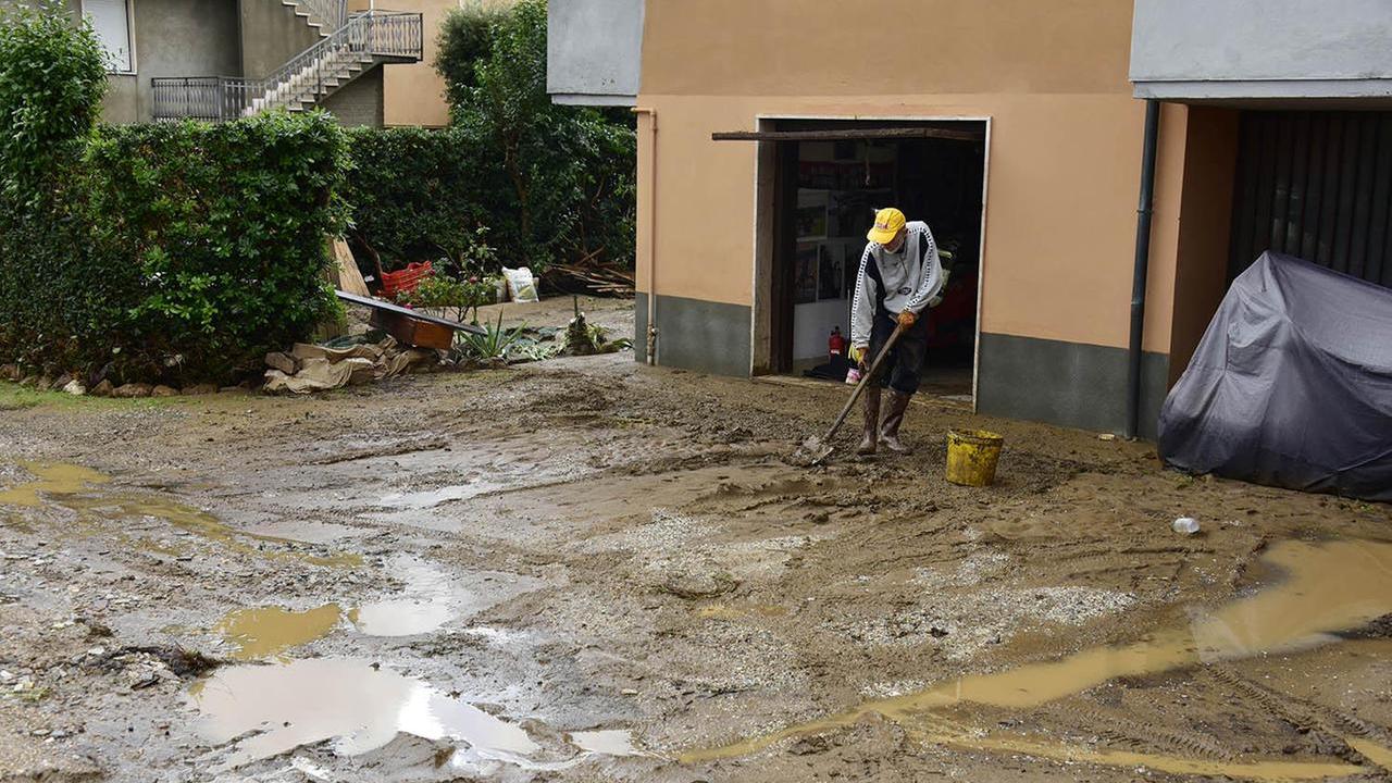 Un uomo che spala il fango dopo l'alluvione a Venturina (Foto Paolo Barlettani)