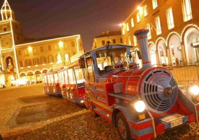 
	Il trenino di Natale in una piazza Grande illuminata

