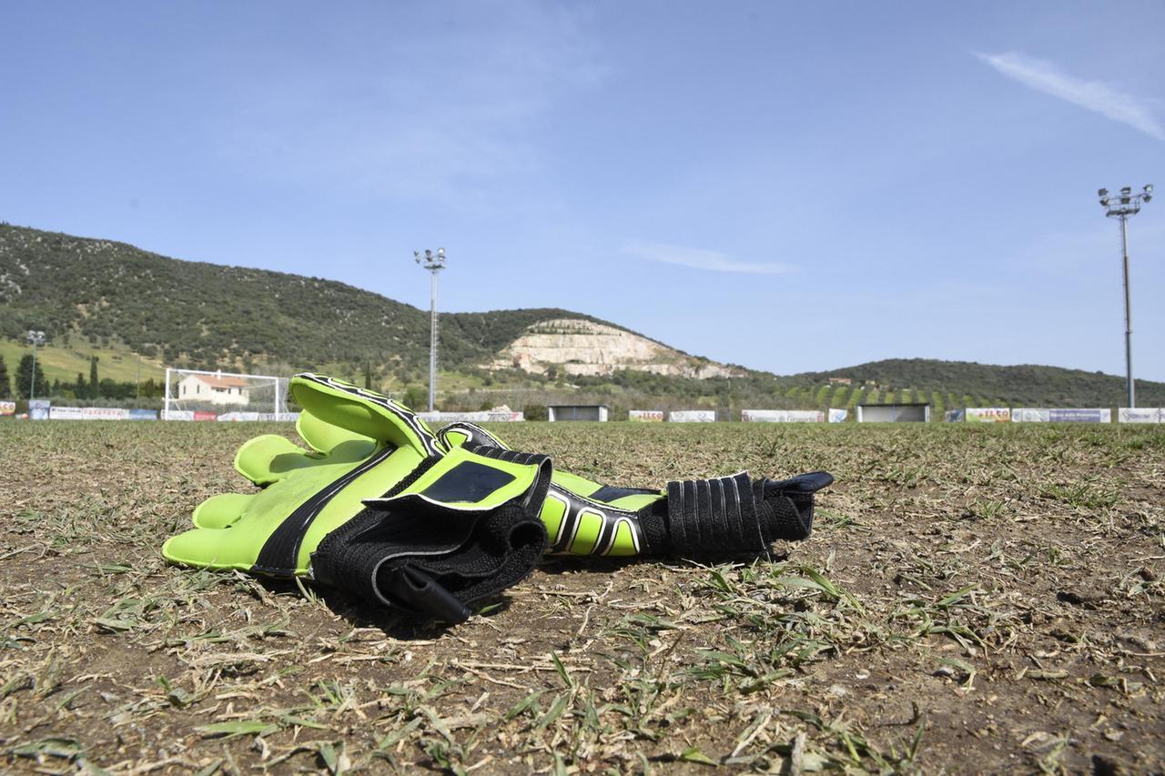Un paio di guanti in mezzo a un campo di calcio (foto di repertorio)