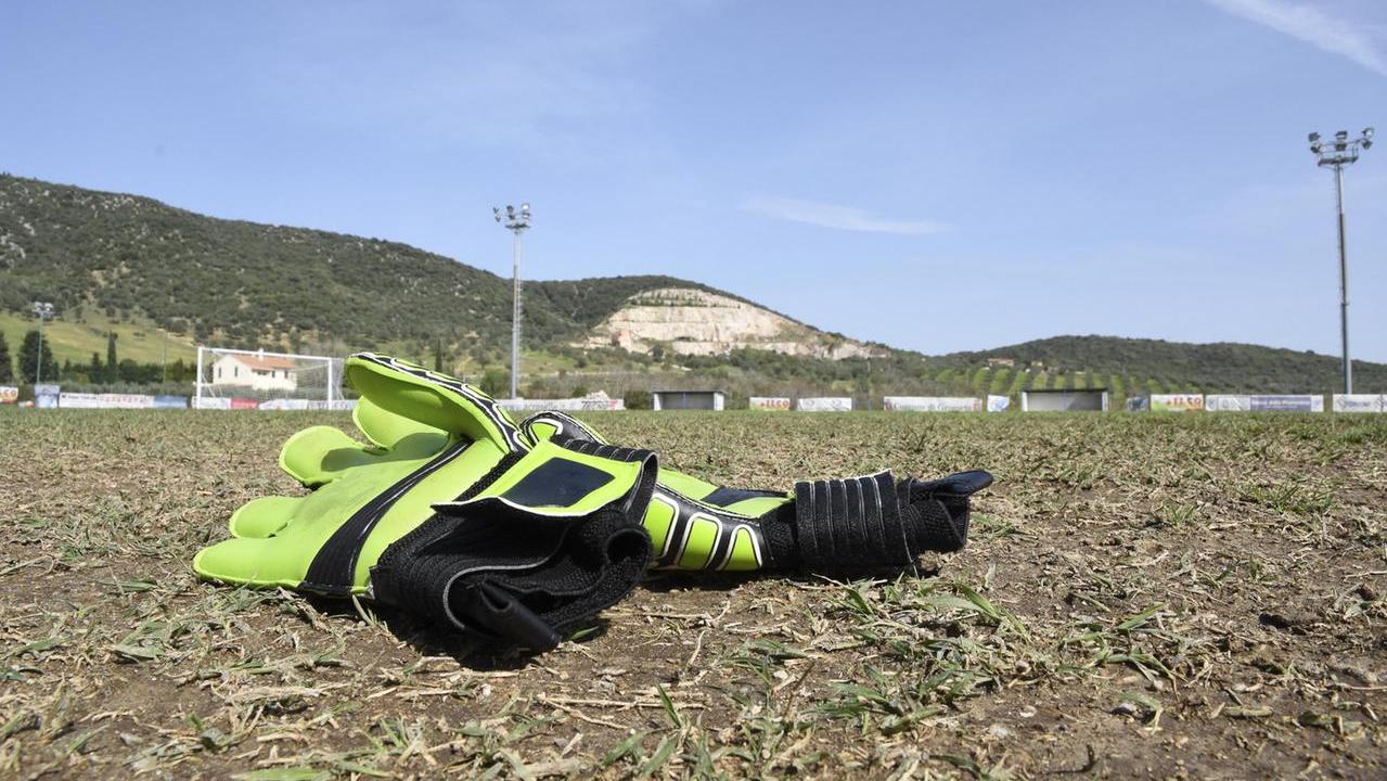 Un paio di guanti in mezzo a un campo di calcio (foto di repertorio)