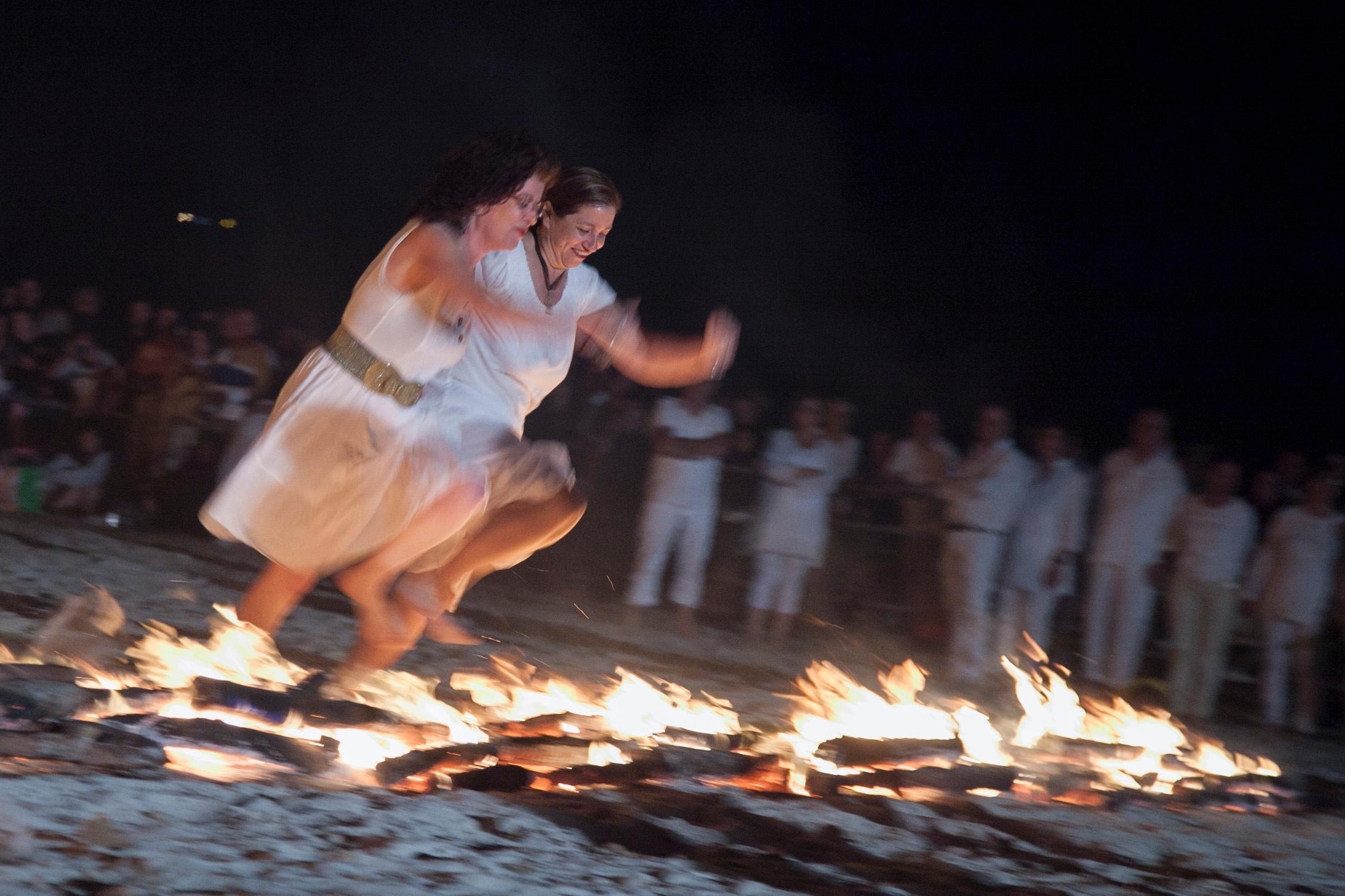 Il salto dell'amicizia durante i fuochi di San Giovanni ad Alghero, un rito simbolico sul sostegno reciproco (foto di Roberto Gabrielli)