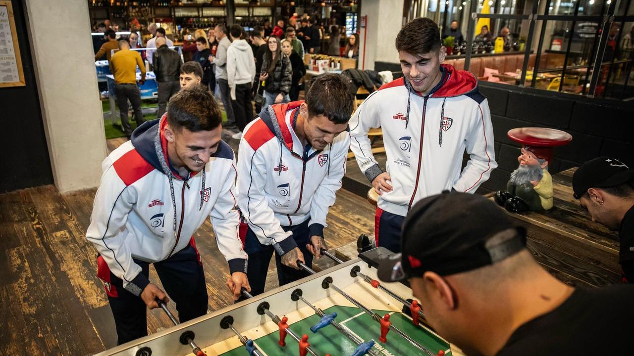 Nicolas Viola, Gabriele Zappa e Adam Obert giocano a calcio balilla con i tifosi del Cagliari