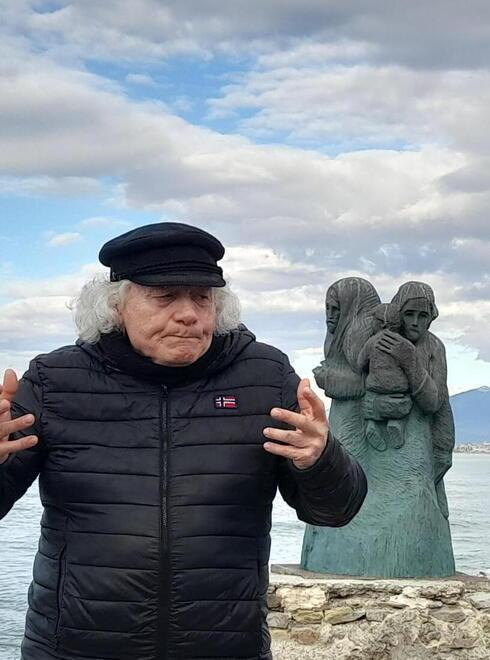 Gionata Francesconi con alle sue spalle "L'Attesa", la scultura che domina il Molo di Viareggio