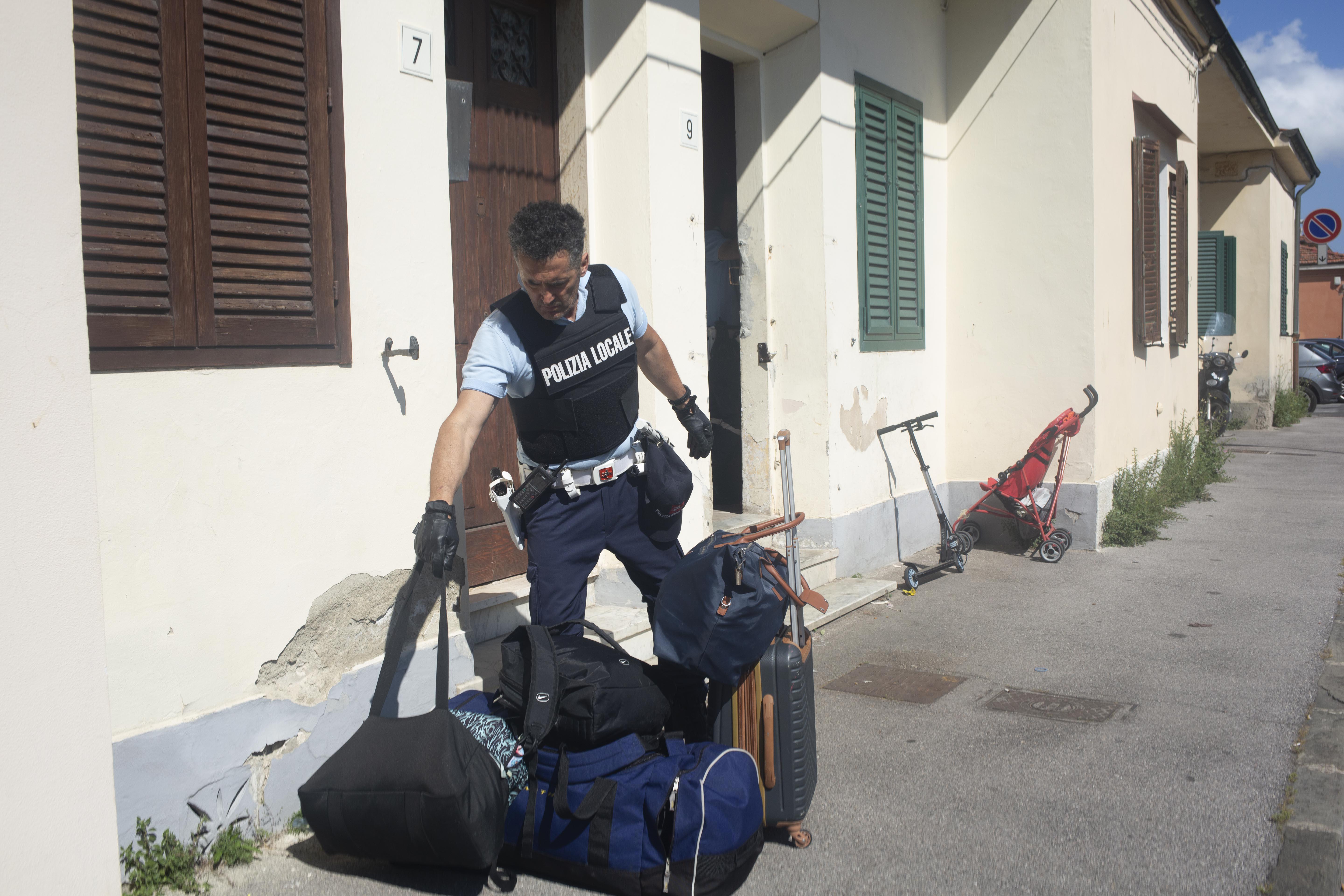 Un agente della municipale impegnato in uno sgombero (foto Silvi)