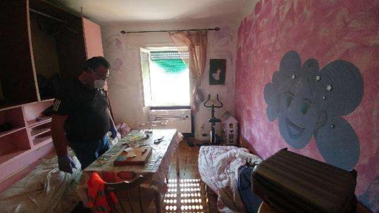 Un carabiniere nella camera da letto dell'alloggio dopo la morte di Denny Magina