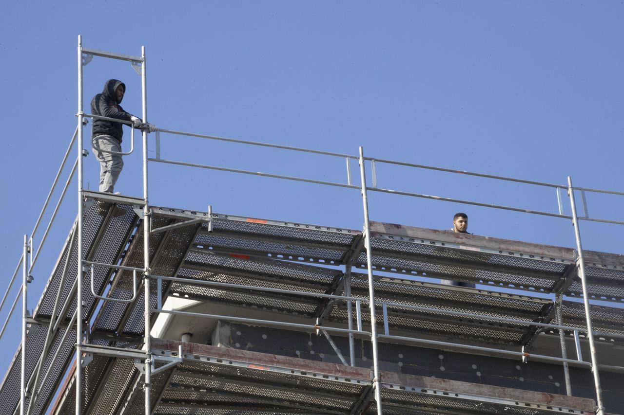 Due operai minacciano di gettarsi dal cantiere di un palazzo