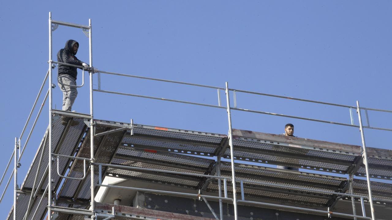 Due operai minacciano di gettarsi dal cantiere di un palazzo