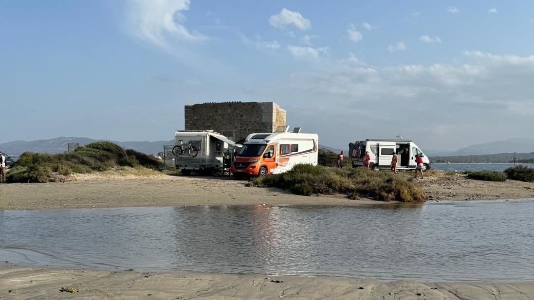 Alcuni camper nella spiaggia di Cala Saccaia