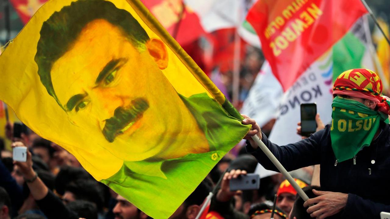 Un'attivisa del Pkk sventola una bandiera con il volto di Ocalan