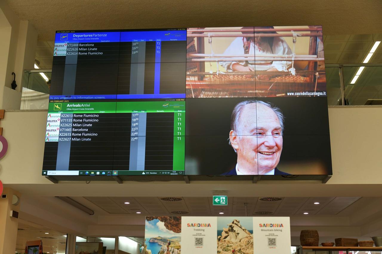 
	Gli schermi dell'aeroporto Costa Smeralda con il volto del principe Karim Aga Khan

