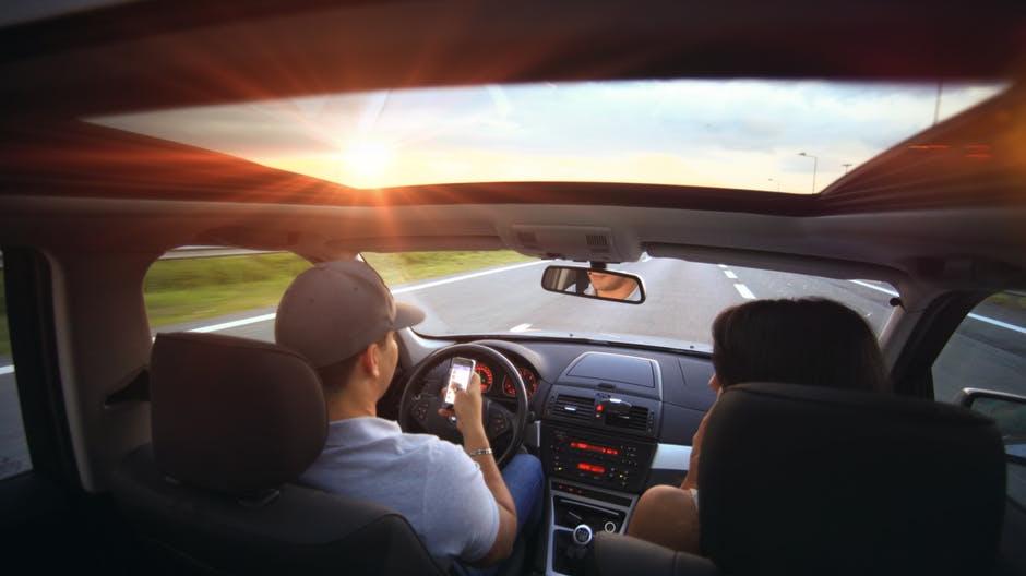 Un uomo alla guida controlla il cellulare, azione pericolosissima oltreché vietata dal Codice della strada (foto d’archivio)