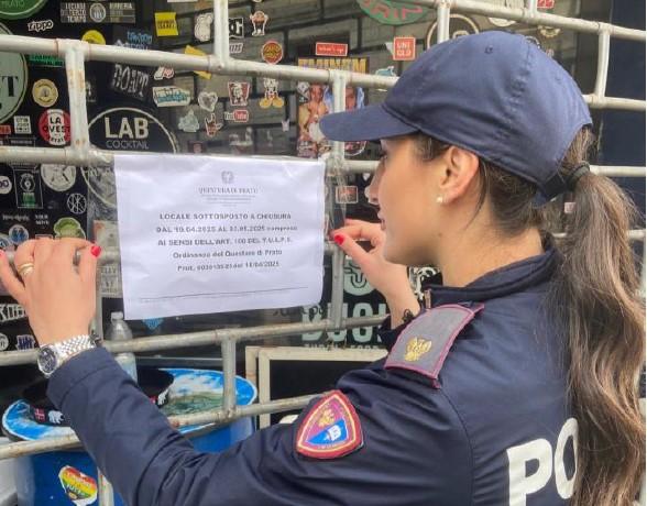 
	Una poliziotta affigge l'avviso di chiusura

