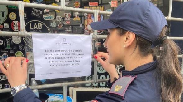 Una poliziotta affigge l'avviso di chiusura