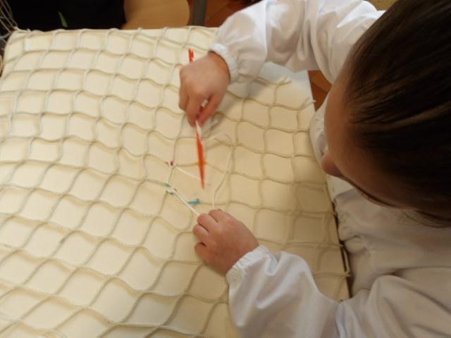 Goro, i bambini rammendano le reti da pesca