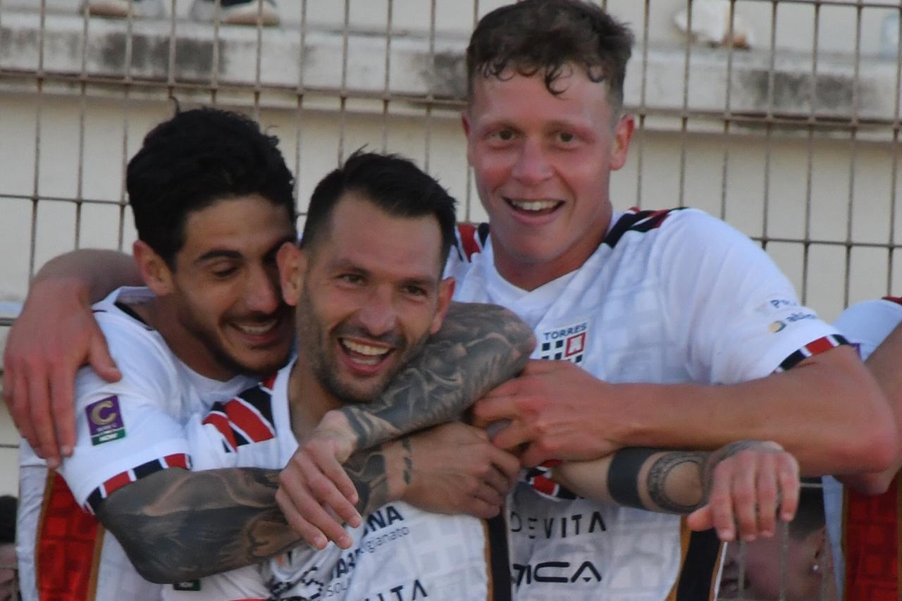 
	L'abbraccio tra capitan Scotto, Giuseppe Mastinu e l'attaccante sanmarinese Nicola nanni

