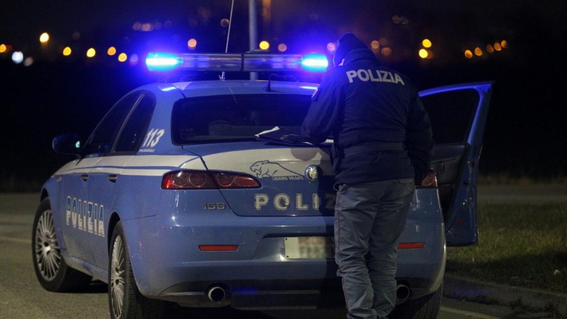 Una volante della polizia e un agente (foto d'archivio)