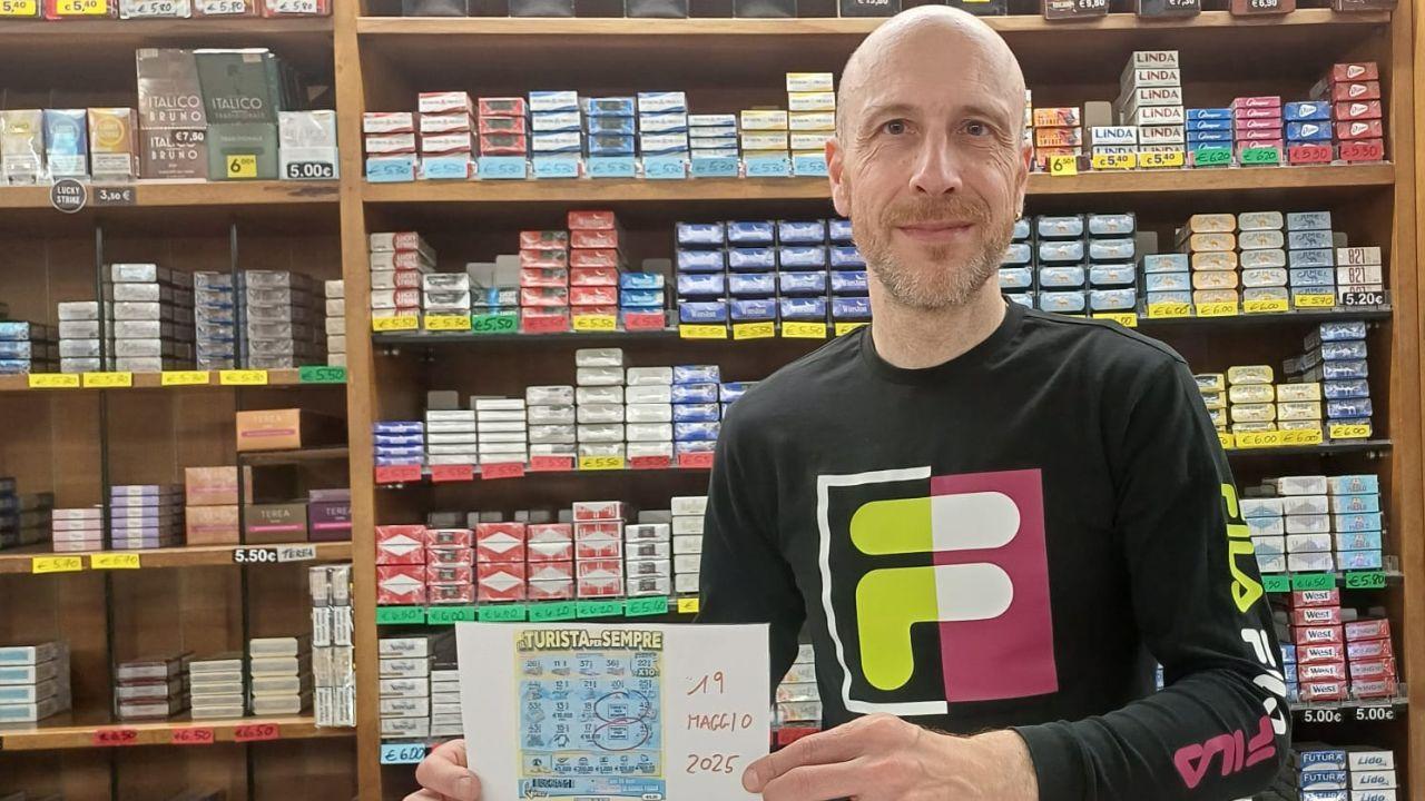 Lorenzo Tempesti, titolare della tabaccheria di via Curtatone e Montanara a Pistoia mostra il biglietto vincente
