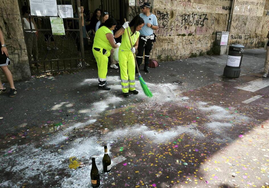 
	La pulizia fuori da una scuola dopo il caos

