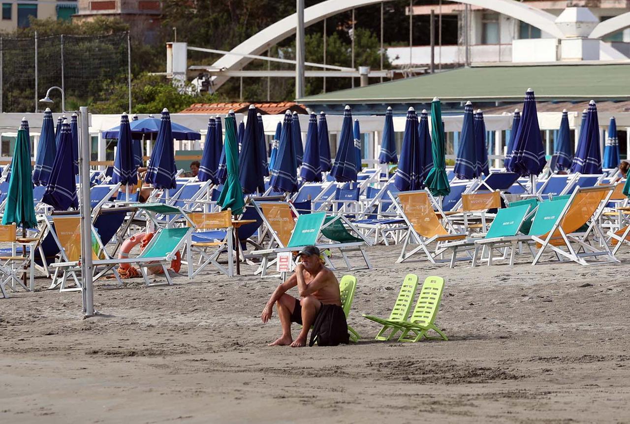 
	Ombrelloni chiusi su una spiaggia del litorale massese


